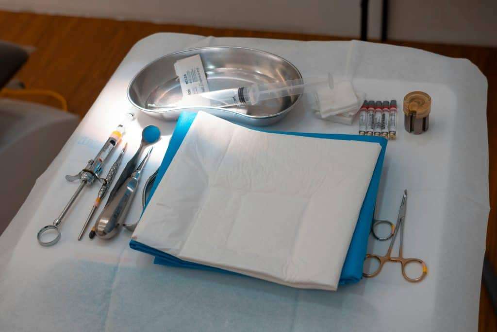 A neatly arranged set of medical instruments and supplies on a sterile surgical tray, ready for use.